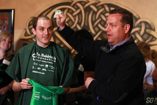 Cory Harwell, right, counts extra money that Nicholas Fortin has collected during the St. Baldrick’s Day head-shaving fundraiser for cancer Saturday, March 1, 2014, at McMullan’s Irish Pub.